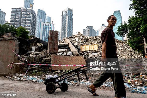Man walks past the ruins of Shibati, an old city area near Jiefangbei. Shibati, characteristic of ladder streets and traditional architectures along...