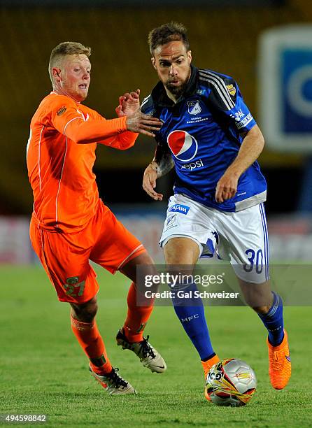 Federico Insua of Millonarios struggles for the ball with George Saunders of Envigado during a match between Millonarios and Envigado FC as part of...