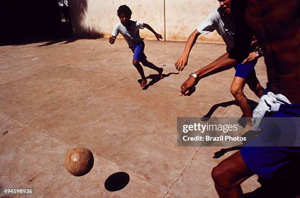 Barefoot boys play soccer in the street, Rio de Janeiro, Brazil.