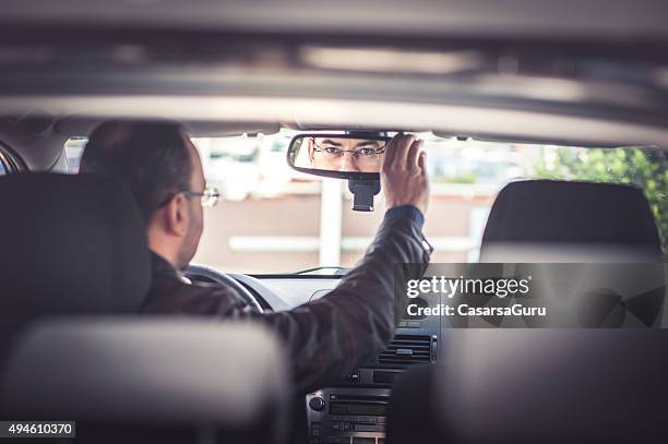 portrait of a man driving a car - rear view mirror stock pictures, royalty-free photos & images