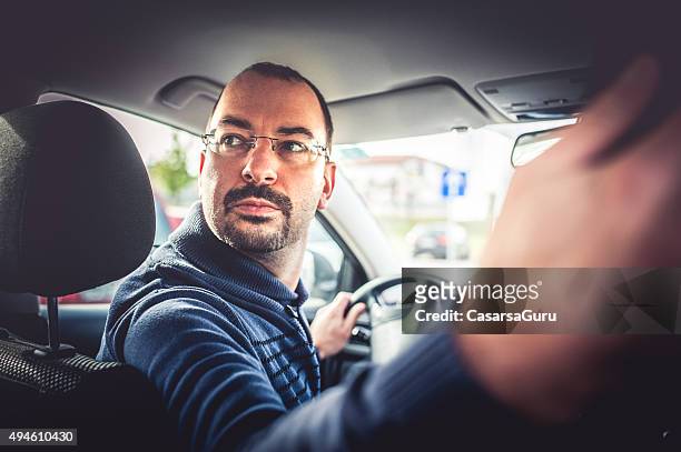 portrait of a man driving a car - reversing stock pictures, royalty-free photos & images