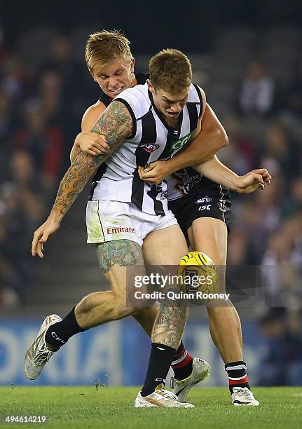 Dayne Beams of the Magpies kicks whilst being tackled during the round 11 AFL match between the St Kilda Saints and the Collingwood Magpies at Etihad...