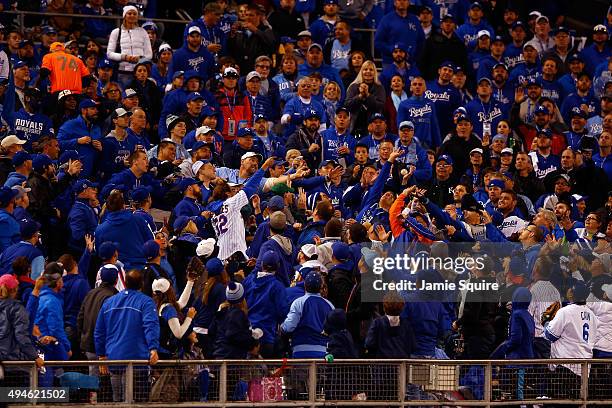 Fans attempt to catch a foul ball during Game One of the 2015 World Series at Kauffman Stadium on October 27, 2015 in Kansas City, Missouri.