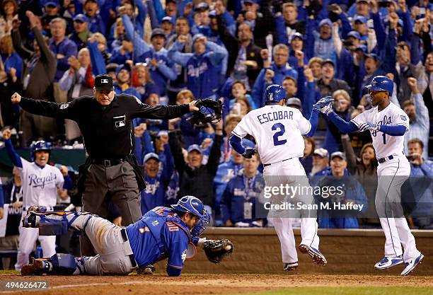 Alcides Escobar of the Kansas City Royals celebrates with Jarrod Dyson of the Kansas City Royals after scoring the game-winning run in the fourteenth...