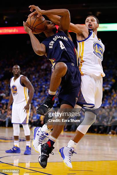 Stephen Curry of the Golden State Warriors blocks a shot by Ish Smith of the New Orleans Pelicans during the NBA season opener at ORACLE Arena on...