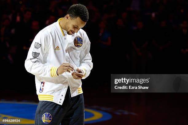 Stephen Curry of the Golden State Warriors admires his championship ring prior to their game against the New Orleans Pelicans in the NBA season...