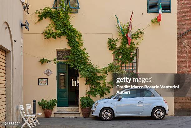 fiat moderne cinqecento garé près du drapeau italien - fiat 500 classic photos et images de collection