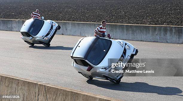 Two rugby players lean from a balancing car and prepare to complete a series of passes as NatWest attempts a Guinness World Record duing 'The World's...