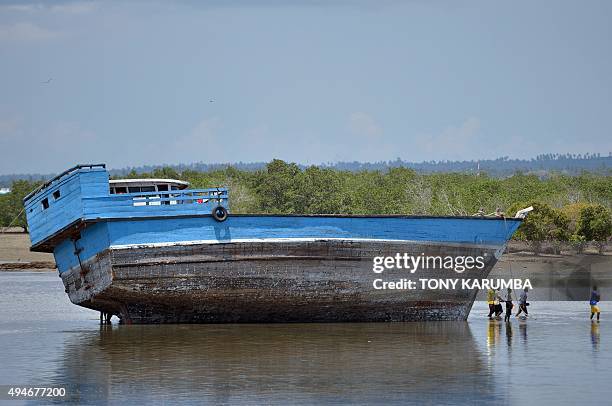 Fishermen leave their beached dhow during low-tide near Stone Town in the semi-autonomous archipelago of Zanzibar on October 28, 2015. AFP PHOTO /...