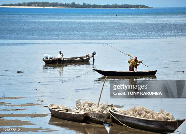 Fishermen return to shore during low-tide near Stone Town in the semi-autonomous archipelago of Zanzibar on October 28, 2015. AFP PHOTO / TONY KARUMBA