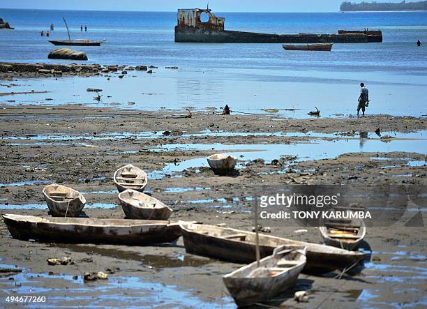 Man walks on the beach during low-tide near Stone Town in the semi-autonomous archipelago of Zanzibar on October 28, 2015. AFP PHOTO / TONY KARUMBA
