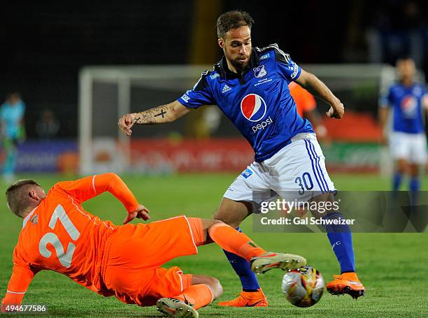 Federico Insua of Millonarios struggles for the ball with George Saunders of Envigado during a match between Millonarios and Envigado FC as part of...