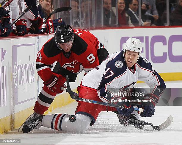 Jiri Tlusty of the New Jersey Devils checks Dalton Prout of the Columbus Blue Jackets at the Prudential Center on October 27, 2015 in Newark, New...