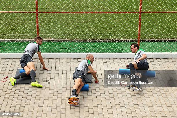James Holland, Mark Bresciano and Luke Wilkshire of the Socceroos stretch during an Australian Socceroos training session at Arena Unimed Sicoob on...