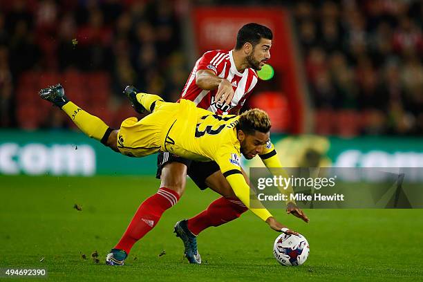 Jordan Amavi of Aston Villa is upended by Graziano Pelle of Southampton during the Capital One Cup Fourth Round match between Southampton v Aston...