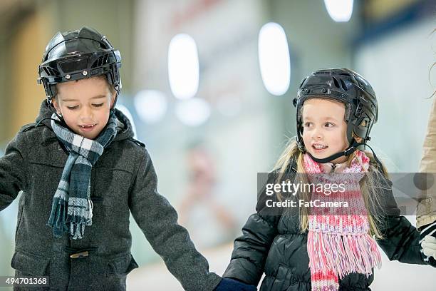 brother and sister skating together - indoor ice skating stock pictures, royalty-free photos & images