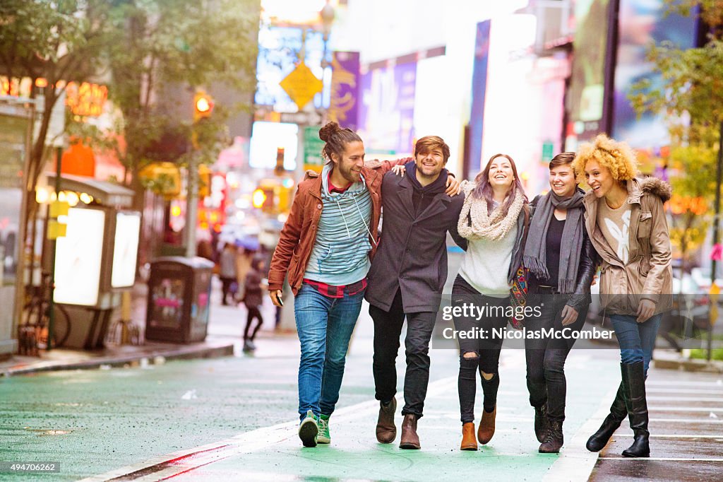 Five friends walking happy in Manhattan wet Autumn day