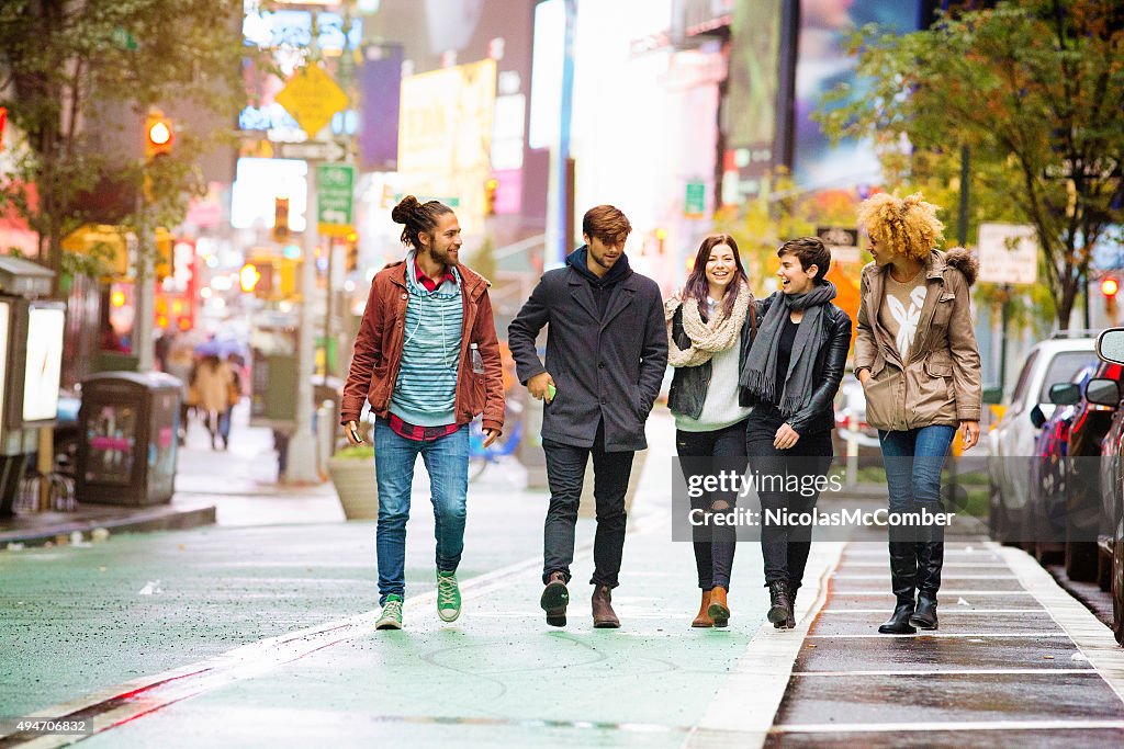 Five friends walking happy in Times square Manhattan