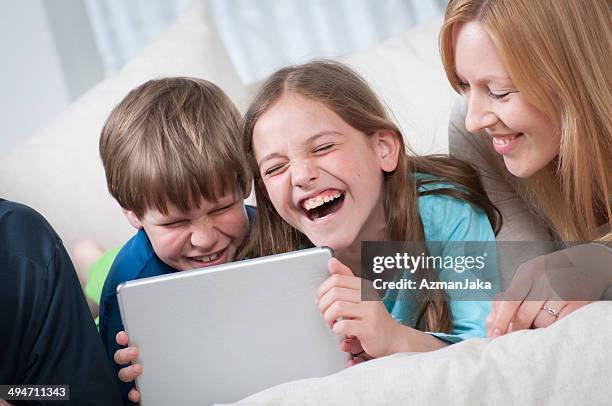 familie mit tablet pc - boy in pajamas and mom on tablet stock-fotos und bilder