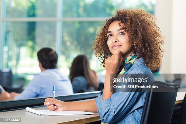 beautiful african american student thinking during test - beautiful college girls stock pictures, royalty-free photos & images