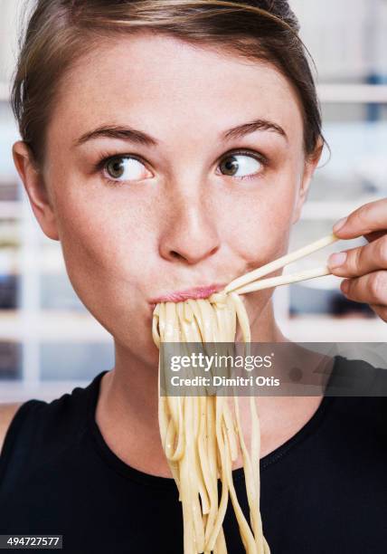 young woman eating asian noodles, close-up - koolhydraat voedsel stockfoto's en -beelden