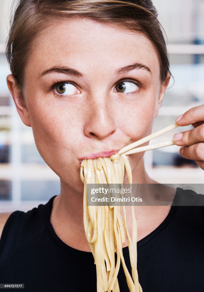 Young woman eating Asian noodles, close-up