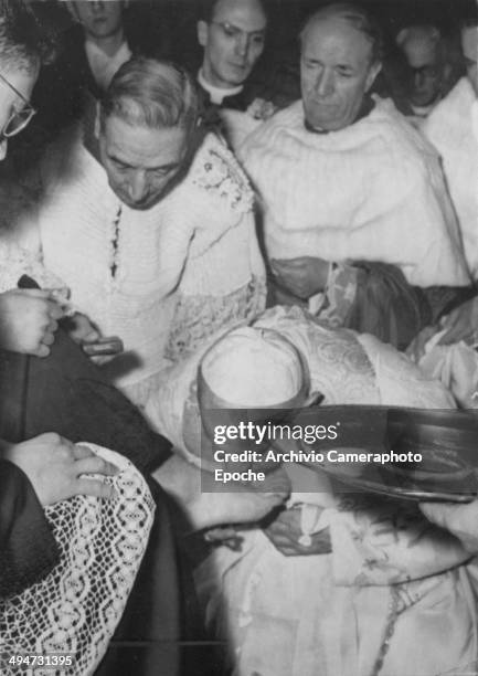 Giovanni XXIII kisses the foot of a young priest during the feet washing ceremony in S. Giovanni March 27 .