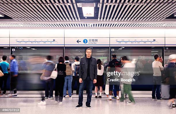 swiss tourist stands out from crowd in hong kong subway - long exposure crowd stock pictures, royalty-free photos & images