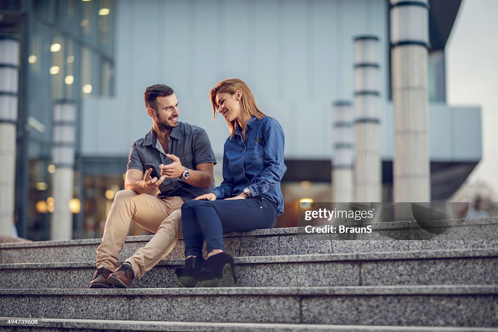 Business people relaxing on staircase and talking about cell phone.