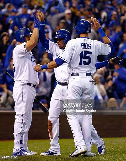 Alcides Escobar of the Kansas City Royals and Alex Rios of the Kansas City Royals celebrate with Kendrys Morales of the Kansas City Royals after...