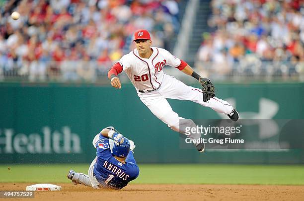 Ian Desmond of the Washington Nationals jumps over Elvis Andrus of the Texas Rangers after forcing him out at second base in the third inning at...