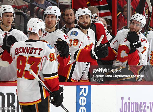 Sam Bennett of the Calgary Flames celebrates his first career NHL goal with team mates David Jones, Deryk Engelland and T.J. Brodie during an NHL...