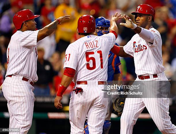 Domonic Brown of the Philadelphia Phillies is congratulated by teammates Marlon Byrd and Carlos Ruiz after he hit a three run home run against the...