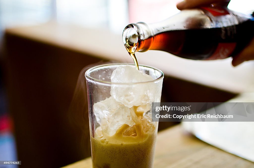 Cola being poured over ice