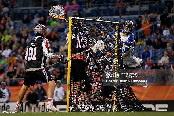 Mike Sawyer of the Charlotte Hounds scores past Jesse Schwartzman of the Denver Outlaws as Dillon Roy and Domenic Sebastiani look on during the...