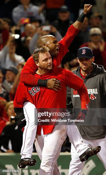 Jonathan Herrera of the Boston Red Sox jumps on the back of A.J. Pierzynski after Pierzynski's game winning RBI triple during the tenth inning of...