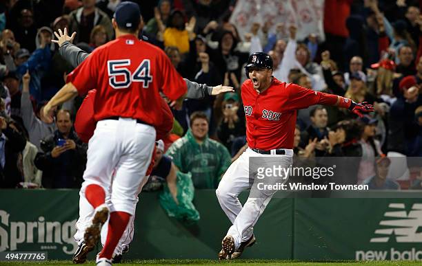 Pierzynski of the Boston Red Sox is greeted by teammates after his game-winning RBI triple during the tenth inning of their 3-2 win over the Tampa...