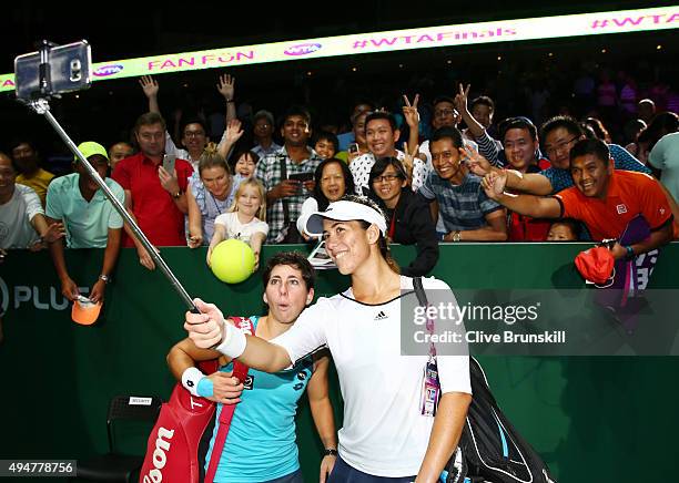 Carla Suarez Navarro and Garbine Muguruza of Spain take a selfie with fans after defeating Hao-Ching Chan and Yung-Jan Chan of Chinese Taipei in a...