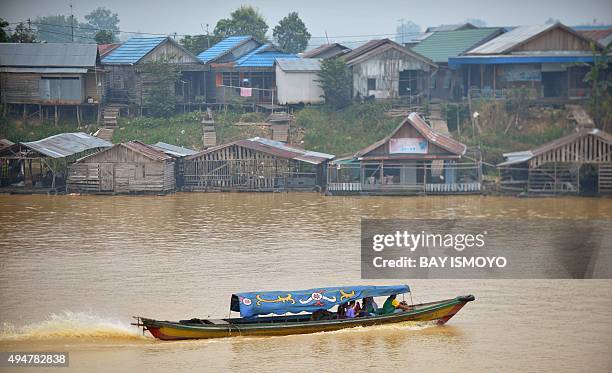 Local residents travel by boat along the Kahayan river in Palangkaraya, in Central Kalimantan, on October 29, 2015 as residents enjoy clearer skies...