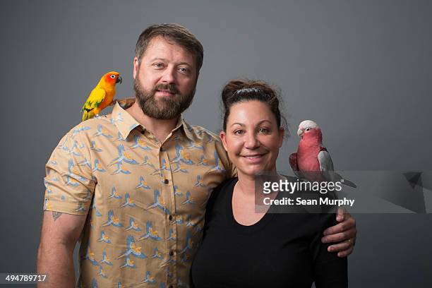 couple with tropical birds on shoulders - two animals ストックフォトと画像