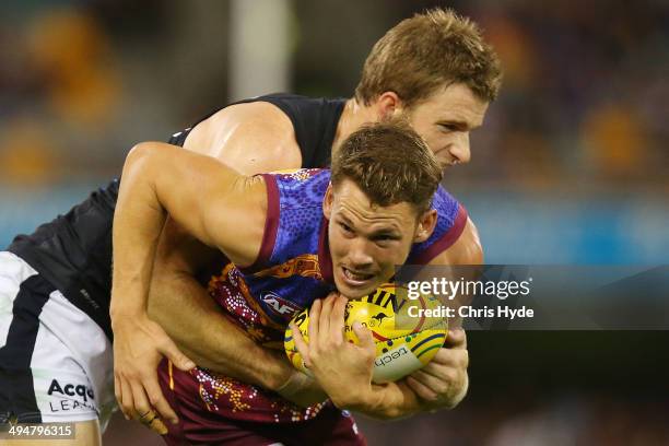 Jack Redde of the Lions is tackled by Lachie Henderson of the Blues during the round 11 AFL match between the Brisbane Lions and the Carlton Blues at...