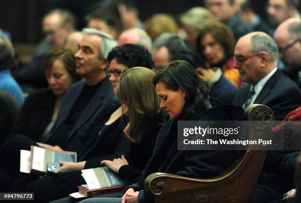 Brigitte Schaefer, center, lowers her head in prayer as she attends a service at Foundry United Methodist Church on Sunday January 26, 2014 in...