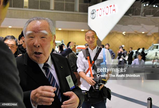 Suzuki Motor Co Chairman Osamu Suzuki questions to a staff at the Toyota Motro Co booth during the Tokyo Motor Show at Tokyo Big Sight on October 29,...