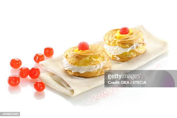 Zeppole di San Giuseppe from Puglia, carnival biscuits filled with whipped cream and decorated with candied cherries, Apulia, Italy.