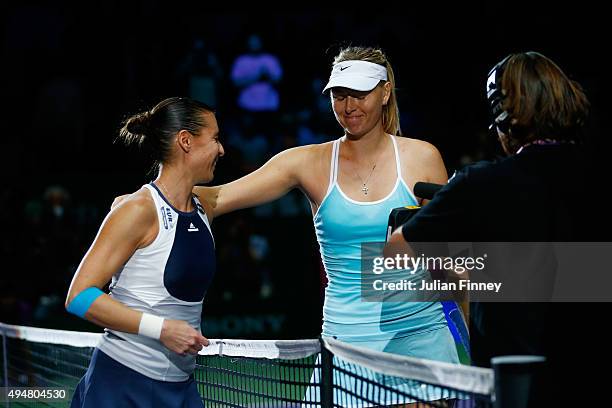 Maria Sharapova of Russia consoles Flavia Pennetta of Italy at the net after a straight set victory in a round robin match during the BNP Paribas WTA...