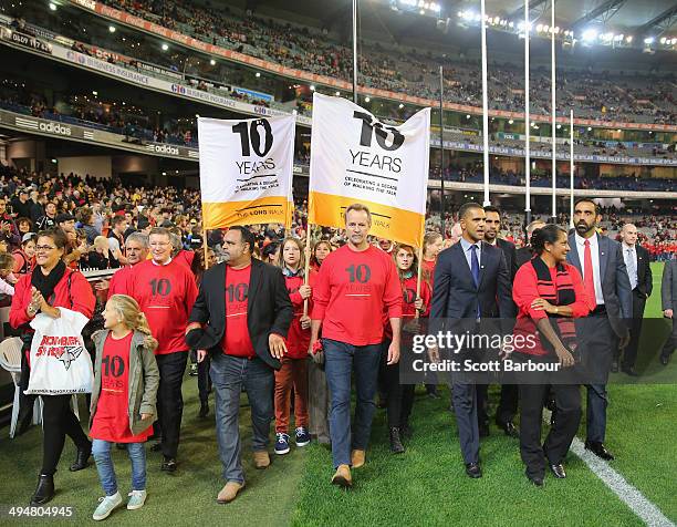 Michael O'Loughlin, Nova Peris, Adam Goodes and Michael Long take part in The Long Walk to Dreamtime at the 'G during the round 11 AFL match between...