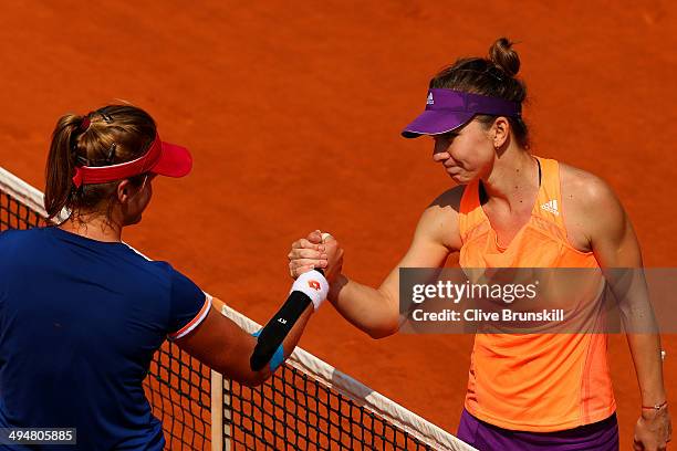 Simona Halep of Romania shakes hands at the net with Maria Teresa Torro Flor of Spain following her victory in their women's singles match on day...