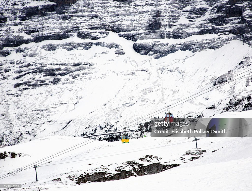 Bright gondolas against snowy Alpine background