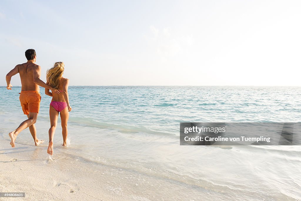 Young couple running into sea