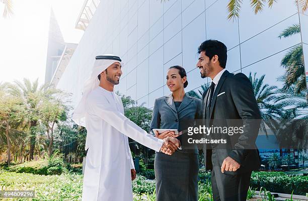 arab personas de negocios estrechándose las manos - gulf countries fotografías e imágenes de stock